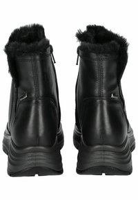 Botas de tobillo de cuero negro con un suave collar de piel sintética, cierres de cremallera y suelas de goma texturizadas para mayor agarre y comodidad.