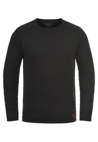 Sweat-shirt noir à manches longues et col rond, fabriqué en tissu texturé, avec des poignets côtelés et une petite pièce en cuir marron à l'ourlet.