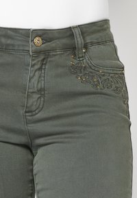 Koroshi BELL  - Šiek tiek platėjantys apačioje džinsai - kaki   khaki