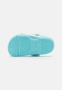 Blue rubber shoe outsole with a textured grip pattern, featuring a circular logo and a smooth toe area. Designed for comfort and traction.