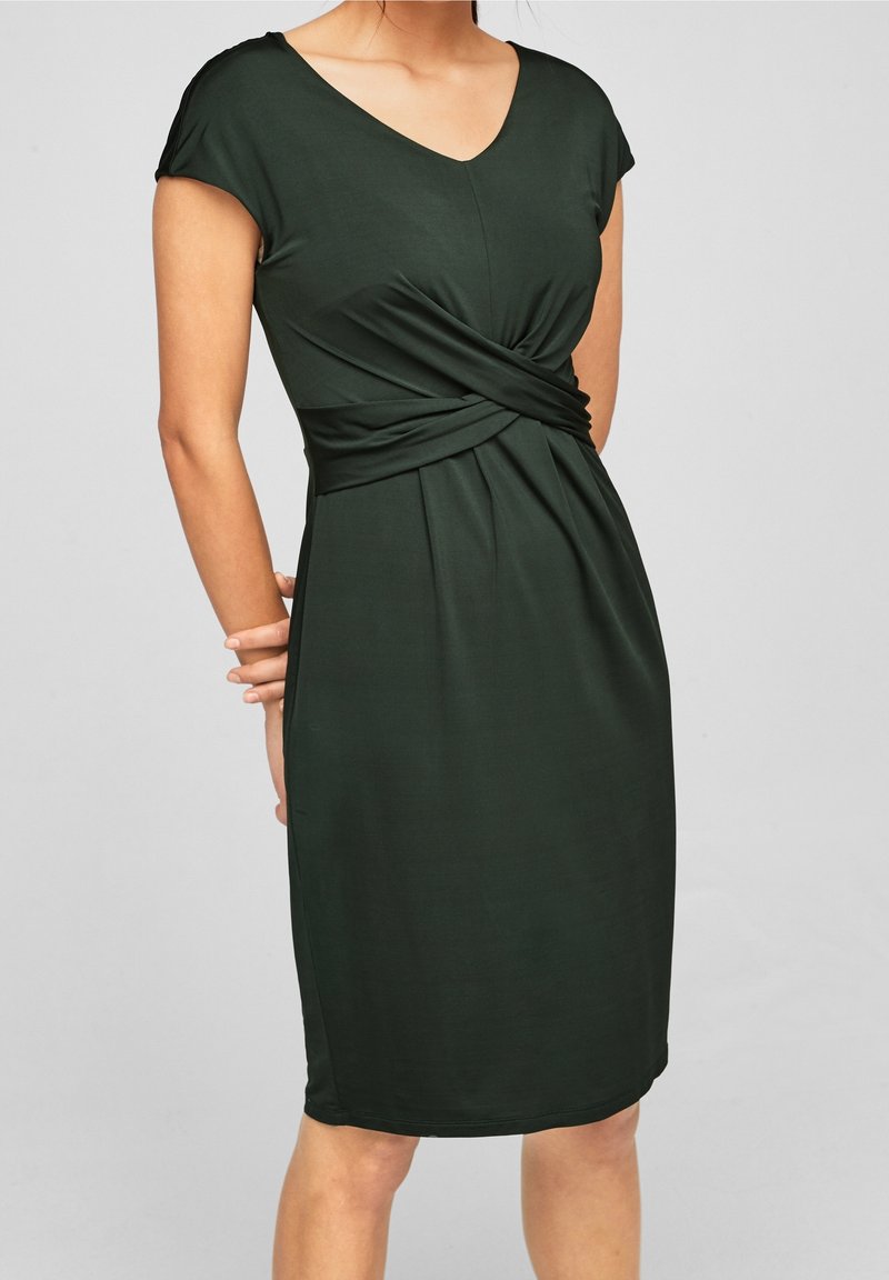 Robe vert foncé en tissu lisse avec un décolleté en V, des manches courtes, et un détail de nœud torsadé à la taille ; design à longueur genou.