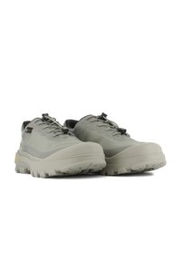 Scarpe outdoor grigio chiaro con tessuto testurizzato, suola spessa e dettagli neri. Presentano un design con lacci e un motivo di battistrada robusto.
