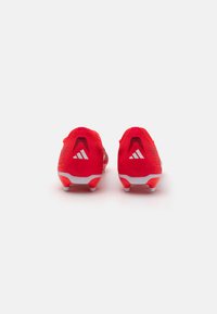 Rote Fußballschuhe mit strukturiertem Obermaterial, weißen Akzenten und einer geschwungenen Ferse. Sie verfügen über drei weiße Streifen und eine Gummisohle mit Noppen.