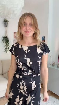 Črna cvetlična obleka z kratkimi rokavi, z nagubanim stranskim dizajnom in kontrastnimi kremnimi cvetličnimi vzorci. Mehka tkanina z tekočo teksturo.