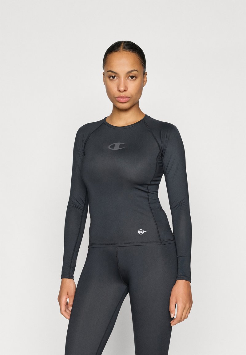 Zwart, aansluitend rash guard met lange mouwen, gemaakt van rekbare stof. Bevat een klein logo op de borst en een contrasterend logo aan de zoom.
