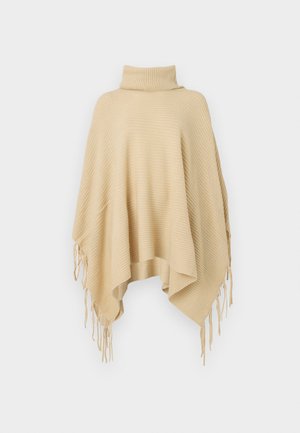 Poncho en tricot beige avec un design à col roulé, présentant une texture côtelée et des bords frangés, offrant un drapé lâche et un ajustement confortable.