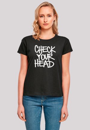 Schwarzes Baumwoll-T-Shirt mit kurzen Ärmeln und rundem Ausschnitt. Mit einem auffälligen weißen Text, der "CHECK YOUR HEAD" lautet.