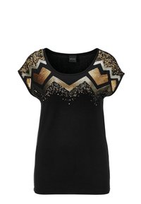 Camiseta negra de manga corta con cuello redondo. Lentejuelas decorativas y acentos texturizados forman un patrón de zigzag en el pecho.