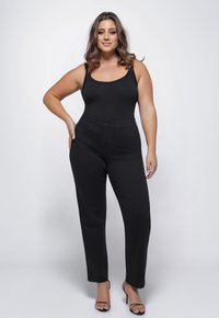 Zwarte hoge taille jeans met een straight-leg ontwerp, voorzien van zakken en een knoopsluiting, gecombineerd met een aansluitend zwart bodysuit.