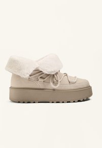 Beige Wildleder-Schuh mit einem Kunstfellbund, runder Zehenform, strukturiertem Sohlenmaterial und verstellbaren Schnürsenkeln. Flacher Plattformfuß mit gerippter Trittfestigkeit.