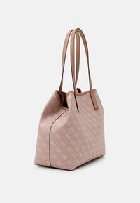 Vaaleanpunainen kangaskassi, jossa on monogrammikuosi, sileä pinta, kaksoiskahvat ja jämäkkä muoto. Tumma vaaleanpunainen yksityiskohta saumoissa.