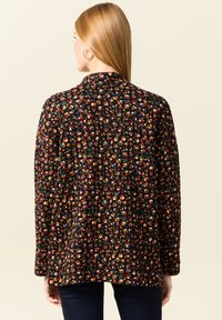 Jasje met bloemenprint in het zwart, met vaakkleurige patronen, lange mouwen en een klassieke kraag. Zachte textuur met een ontspannen pasvorm.