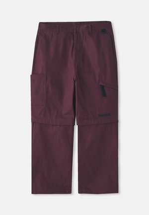 Pantaloni cargo convertibili bordeaux con tasca laterale con zip e logo Timberland sulla gamba destra, mostrano una lunghezza gamba estesa.