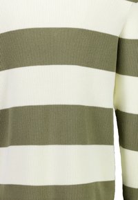 Sweter dzianinowy z naprzemiennymi pasami w oliwkowym zielonym i białym kolorze, charakteryzujący się prążkowaną teksturą. Zbliżenie ukazujące materiał i wzór.