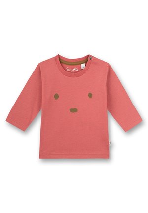 Camiseta de algodón color coral de manga larga, con un diseño sencillo de rostro en marrón. Incluye un escote redondo y un botón a presión en el hombro.