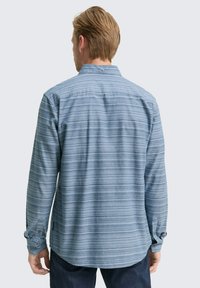 Lange mouwen shirt in lichtblauw met horizontale strepen. Heeft een button-down kraag en manchet met twee knopen. Zachte textuur, casual ontwerp.