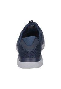 Marineblaue Sportschuhe mit einem strukturierten Mesh-Obermaterial, einem stabilen Fersenbereich und einer weißen Gummisohle. Mit einer Fersenschlaufe für einfachen Zugang.