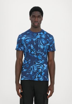 Blue patterned t-shirt with intricate floral design, short sleeves, round neck, and a smooth texture, paired with dark cargo pants.