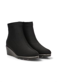Botines de cuña negros hechos de un tejido elástico, con un diseño sin costuras, puntera redondeada y suela de goma texturizada con un sutil acento metálico.