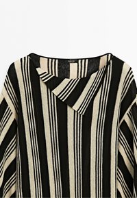 Black and beige long-sleeve shirt with vertical stripes and an asymmetric collar against a white background.