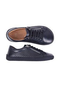 Baskets basses en cuir noir avec fermeture éclair latérale, détails perforés, lacets noirs et doublure intérieure beige, vues de côté et de dessus.