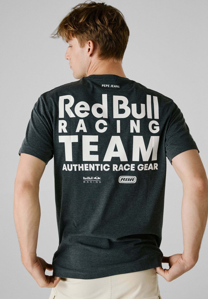 Mørkegrå t-shirt lavet af bomuld med korte ærmer. På ryggen står der med store hvide bogstaver: "Red Bull Racing TEAM AUTHENTIC RACE GEAR."
