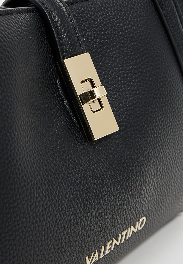 Bolso de piel negra texturizada con un cierre de metal dorado y el nombre de la marca "Valentino" grabado en la parte inferior.