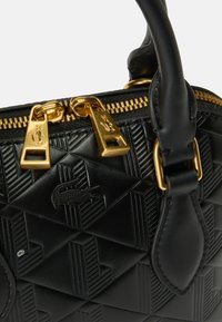 Zwarte leren handtas met een geometrisch reliëfpatroon, gouden ritsen en een krokodillenlogo-detail. Gladde textuur en gestructureerde vorm.