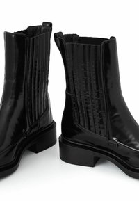 Czarne lakierowane botki za kostkę na słupkowym obcasie. Charakteryzują się pionowymi żebrowaniami po bokach oraz gładkim, błyszczącym wykończeniem.