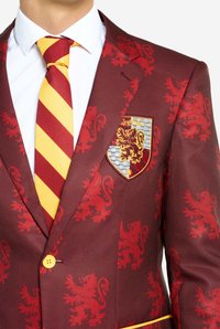 Burgundi ülikonna jaotur punase lõvipaigutusega, kollaste nuppudega ja Gryffindori embleemiga. Kombineeritud kollase ja punase triibulise lipsu ning valge särgiga.