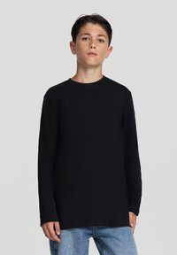 Maglietta nera a maniche lunghe con scollo rotondo, realizzata in tessuto morbido. Caratterizzata da una vestibilità rilassata e un design semplice senza motivi o decorazioni.