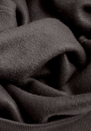 Donkergrijze stof met een zachte, gestructureerde oppervlakte, voorzien van gelaagde plooien en een geribbelde zoom. Het materiaal lijkt warm en gezellig.