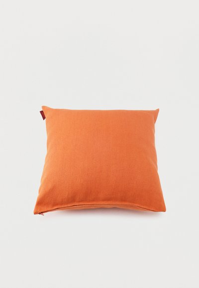 Square orange fabric cushion with a small fabric tag on the upper left side against a plain white background.