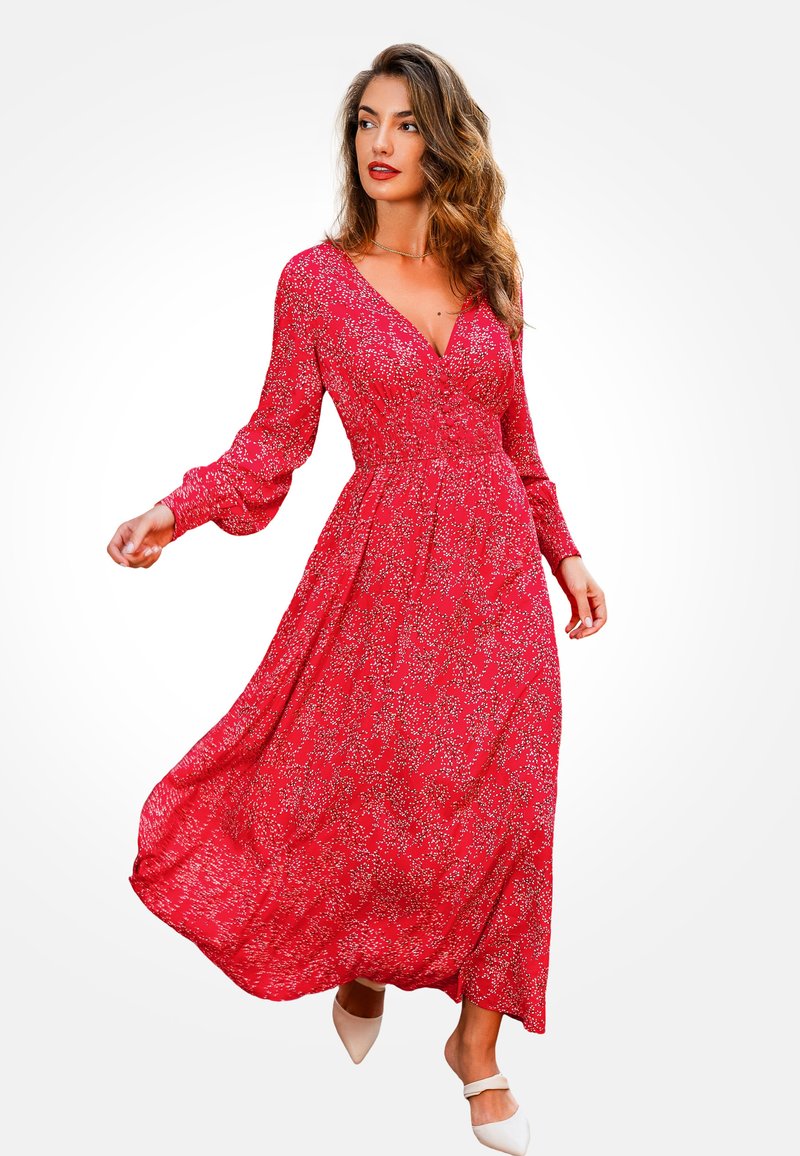 Vestido largo rojo con flores, de mangas largas, escote en V y cintura elástica. Tela fluida con textura ligera, decorada con pequeñas flores blancas.