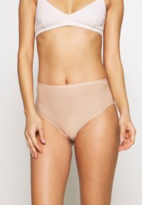 High-waisted, nude-colored underwear made from smooth, stretchy fabric. Features minimal seams and a comfortable waistband design.