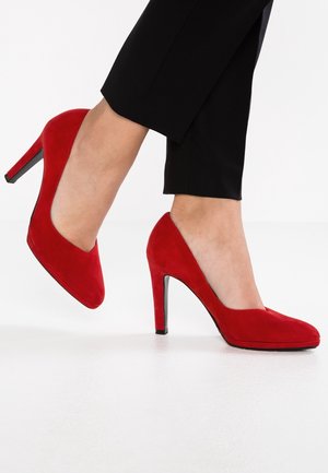 Røde ruskinds højhælede sko med rund tå og elegant design. Har en sort stilettohæle og en glat overflade.