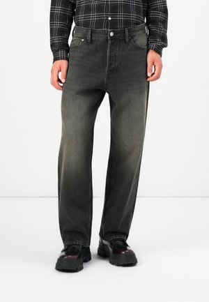 Dark gray denim jeans with a straight-leg fit, front pockets, and subtle fading. Paired with black boots and a plaid, button-up shirt.