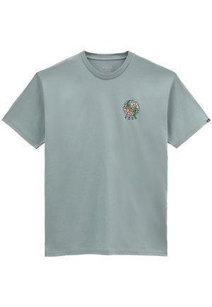 T-shirt en coton vert clair avec des manches courtes et un col rond. Un logo floral avec "VANS" apparaît sur la poitrine gauche.
