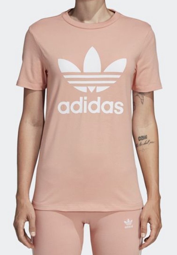 Rosa bomull t-shirt med en stor vit Adidas-logotyp och tre ränder under. Korta ärmar och klassisk rund halsringning.
