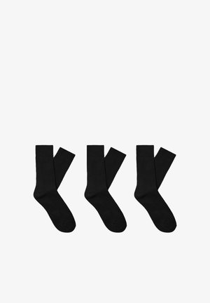 Sorte bomuldsstrømper arrangeret i en række, med ribbet struktur og et knæhøjt design med forstærket tåområde.