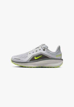Grauer Sportschuh mit strukturierter Oberfläche, neongrünen Akzenten, einer gepolsterten Sohle und einem leichten Design. Verfügt über ein sichtbares Logo und Details.