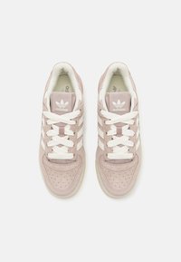 Ljusrosa mockasneakers med vita detaljer, med perforerad tå, rundad form och platta snören. Logotyper på tungan och sidan.