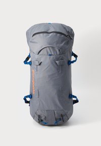 Γκρίζος σακίδιο με στρογγυλή κορυφή, μπλε ιμάντες και πορτοκαλί λογότυπο. Διαθέτει μια τσέπη με φερμουάρ και πολλούς ιμάντες για προ σαρμογή. Ανθεκτικό ύφασμα.