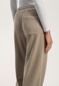 Ruske sweatsukse made of soft fabric. Poiketaan sellaista takataskua ja joustavaa vyötärönauhaa. Näyttää lähikuvan sivusta ja takaa.