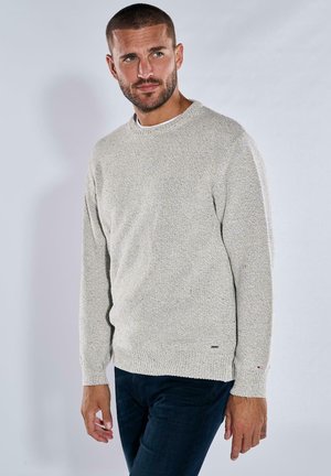Light gray knit sweater with textured fabric, round neckline, and ribbed cuffs. Features a small logo accent at the hem.