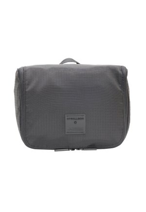 Black nylon toiletry bag with a textured surface, rectangular shape, zip closure, and a top handle. Features a logo patch on the front.