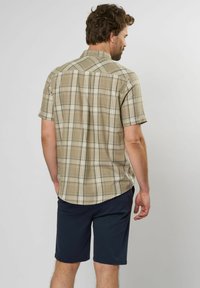 Korte mouw plaid shirt in beige met groene en witte lijnen, gecombineerd met donker marineblauwe shorts. Katoenmengsel stof, rugpasvormdetails.