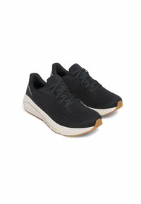 Black athletic shoes with a breathable mesh upper, grey laces, and white midsole. The textured rubber outsole features a gum-colored tip.