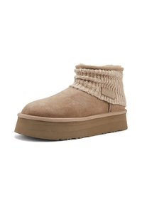 Svjetlosmeđi antilop cipele do gležnja s rebrastim pletenim okvirom, s debelim platformom i teksturiranom površinom, što naglašava udobnost i toplinu.