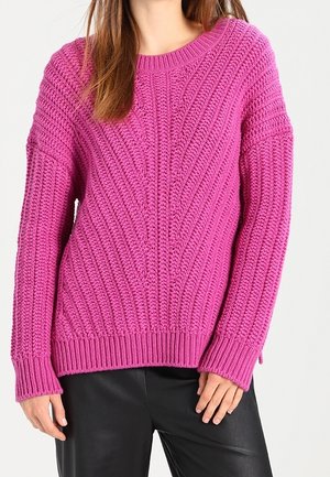 Maglione rosa lavorato a maglia con modelli a treccia testurizzati, scollatura rotonda e maniche lunghe. Fondo a coste, vestibilità comoda e texture morbida.